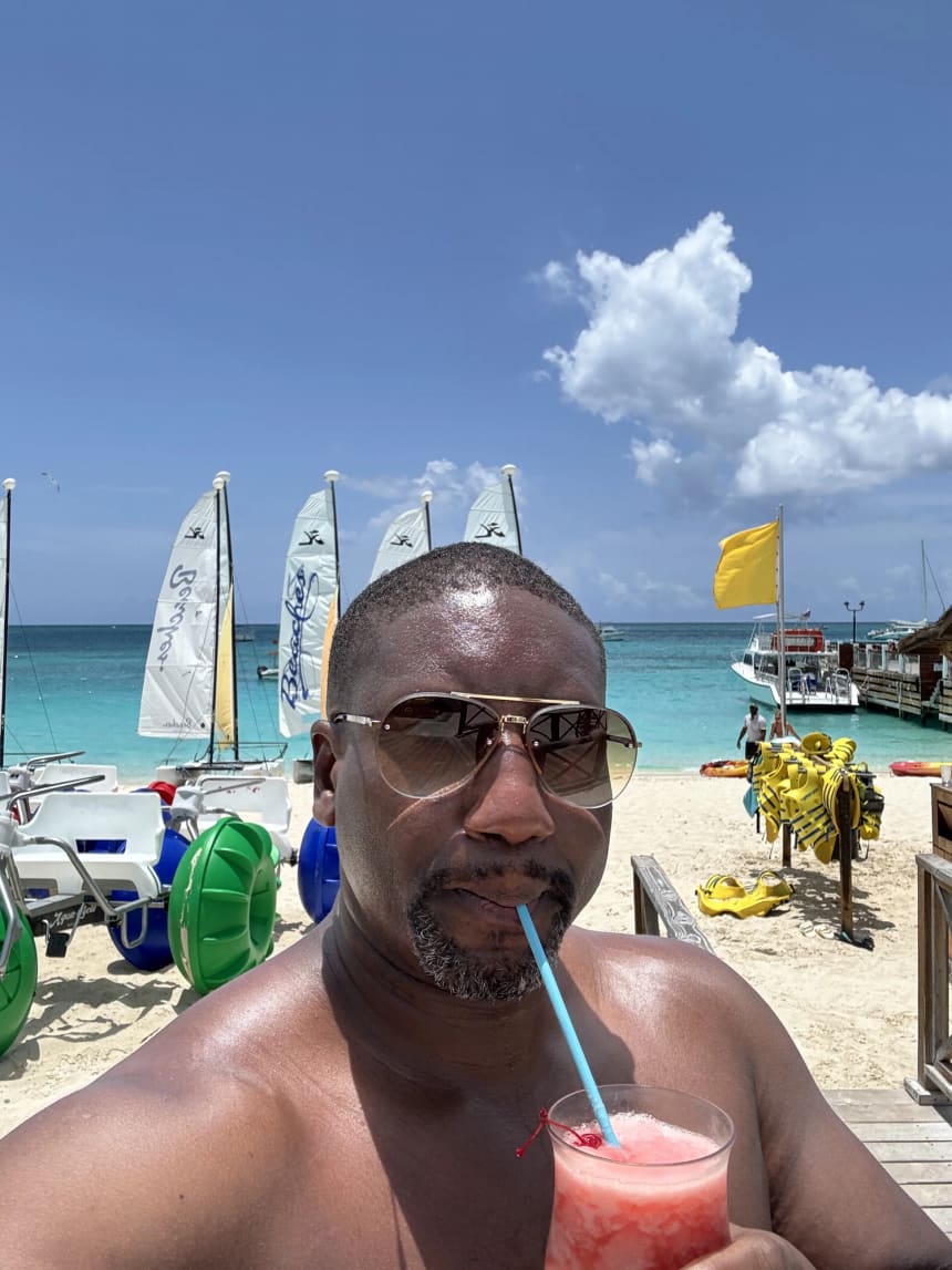 Traveler enjoying a drink on the beach during a family stay at Beaches Turks & Caicos.