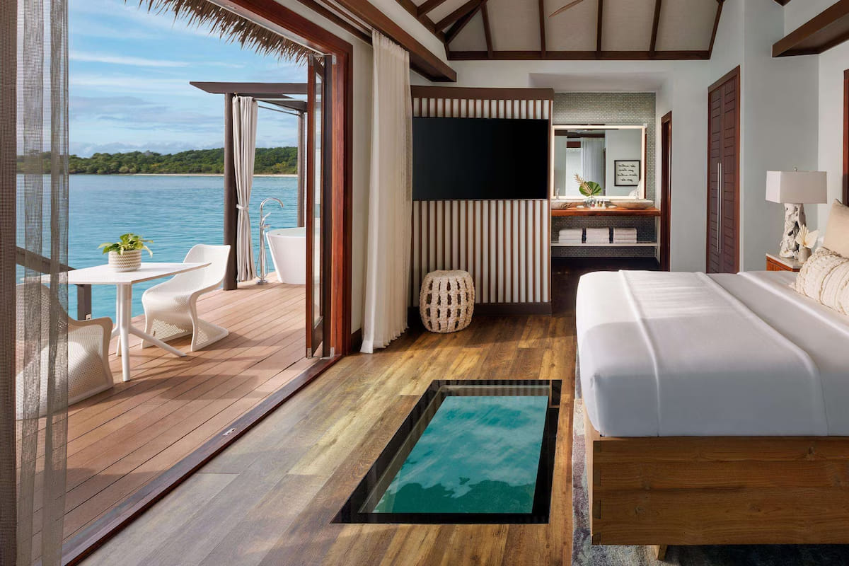 Bedroom inside a Sandals South Coast villa with a glass floor and Caribbean Sea view